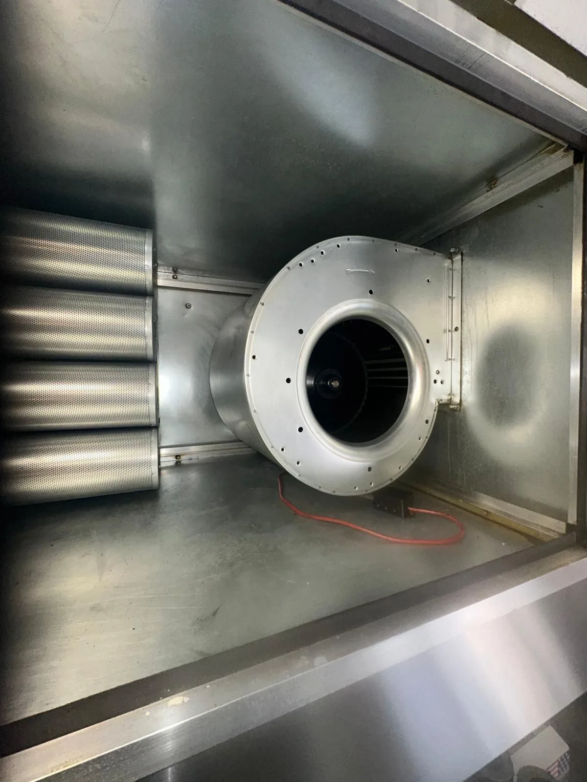 Gereinigde technische luchtbehandelingsruimte met zichtbare ventilatorunit.